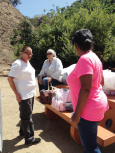OPCC social workers Maureen Rivas (left) and Glanda Sherman (right) help a homeless woman find housing.